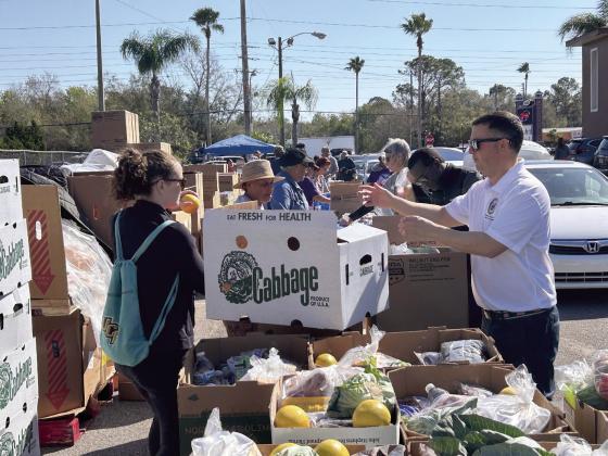 Congressman Darren Soto was one of the volunteers Friday morning at a Second Harvest Food Bank food distribution at the Central Motel on west U.S. Highway 192. PHOTO/THOMAS OUELLETTE