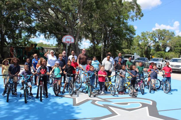 About 30 Kissimmee after-school program participants received free bikes Wednesday from the City of Kissimmee and Waste Management for making the A/B honor roll. PHOTO/KEN JACKSON