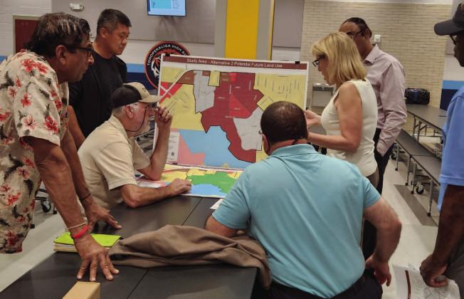 Residents and Osceola County planning staff go over potential future land use changes, which include new land zoned for industrial use, at a community meeting Feb. 22 at Tohopekaliga High School. PHOTO/KEN JACKSON